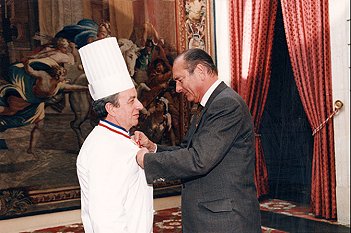 Photo 1 : Président Jacques Chirac remet les insignes de chevalier de la Légion d'Honneur M. Jöel Normand, chef de cuisine de la Présidence.